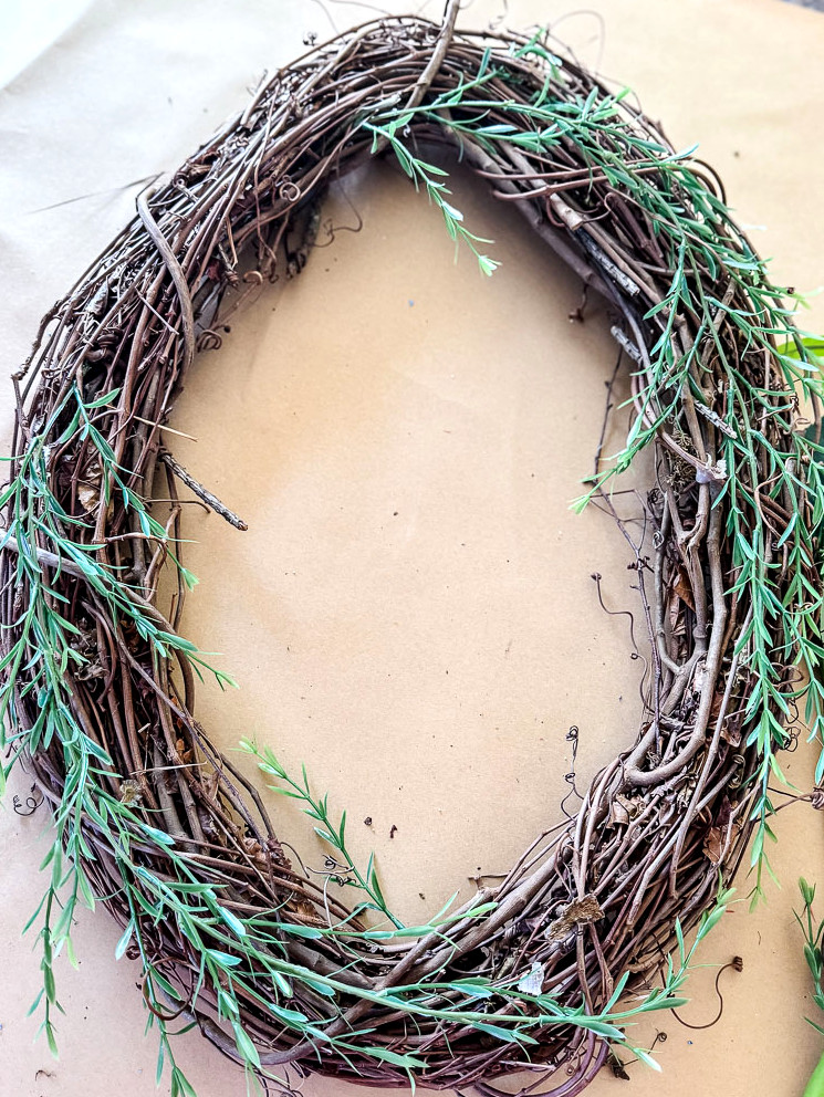 a grapevine wreath with greenery 