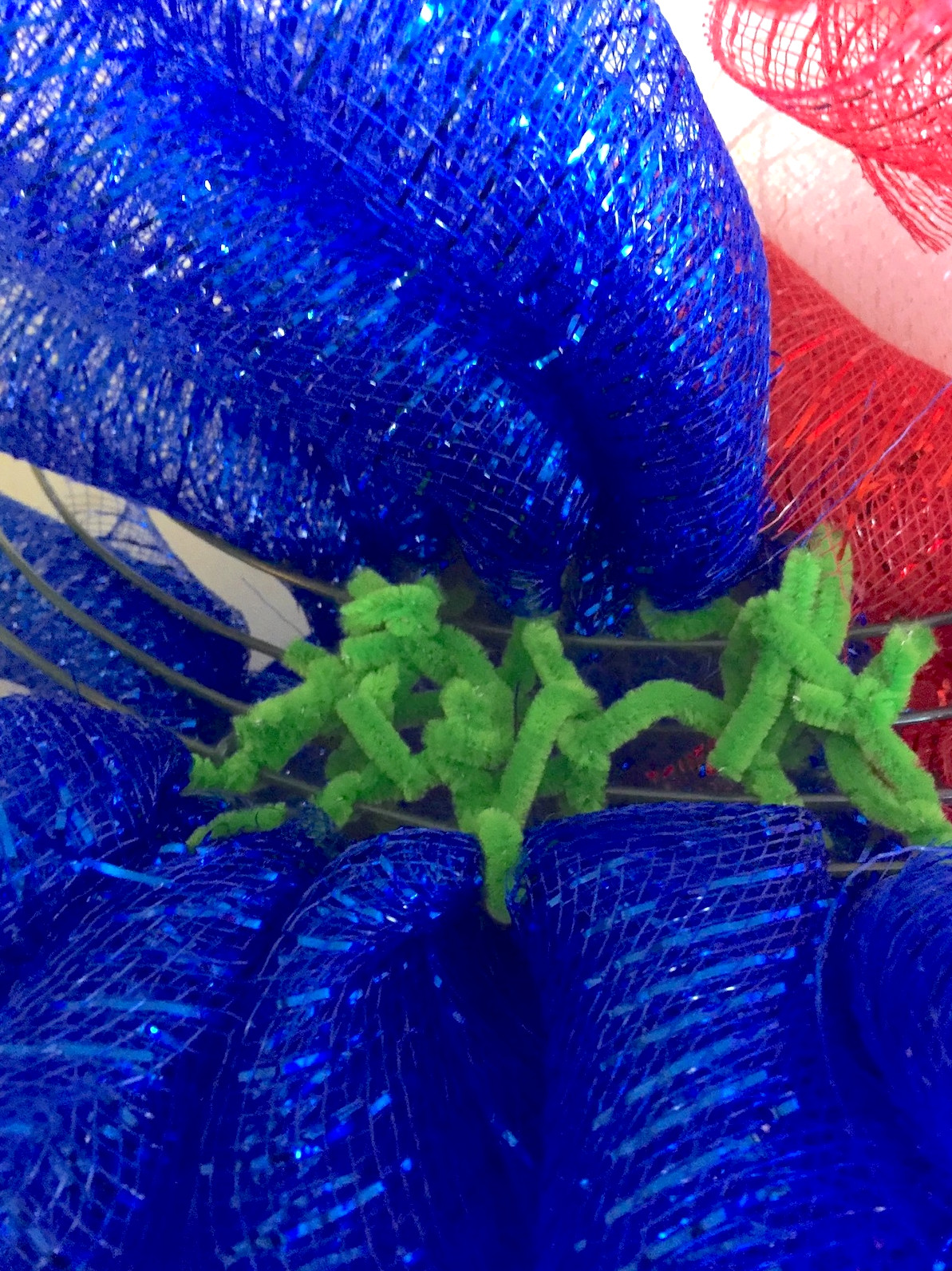 Twisting pipe cleaner ties behind a wire wreath form