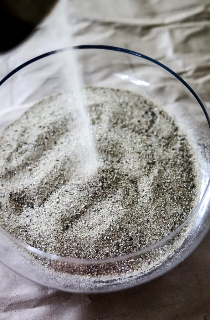 pouring sand into terrarium bowl