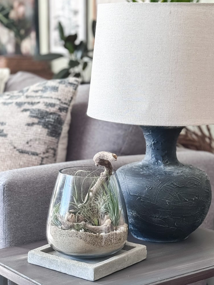 air plant terrarium on end table with black lamp