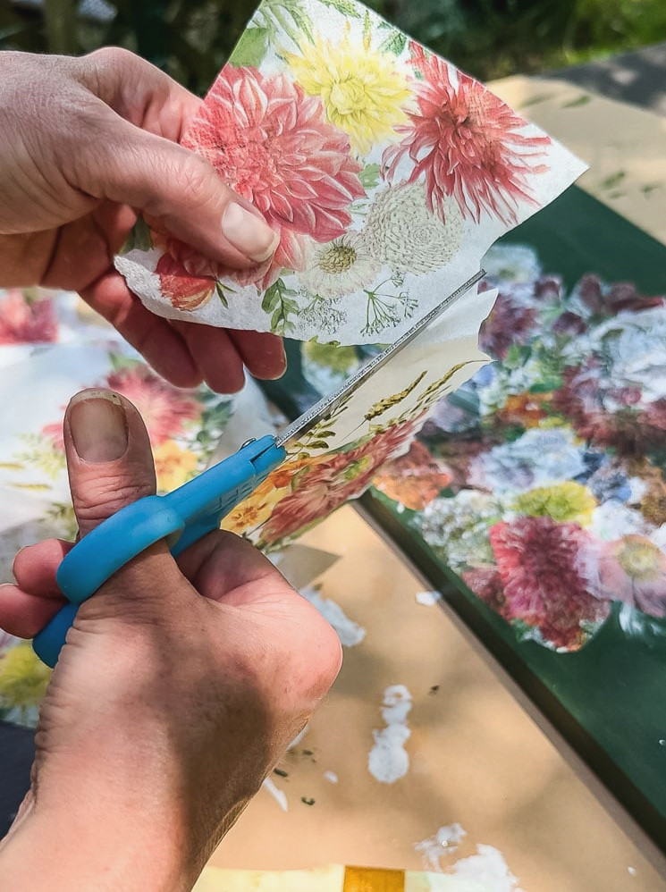 cutting a flower out of a paper napkin