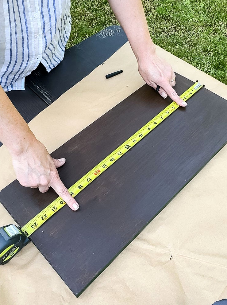 using a tape measure to measure a board