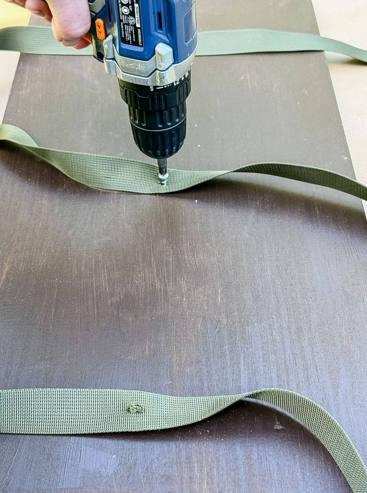 drilling a nylon strap into a wood board