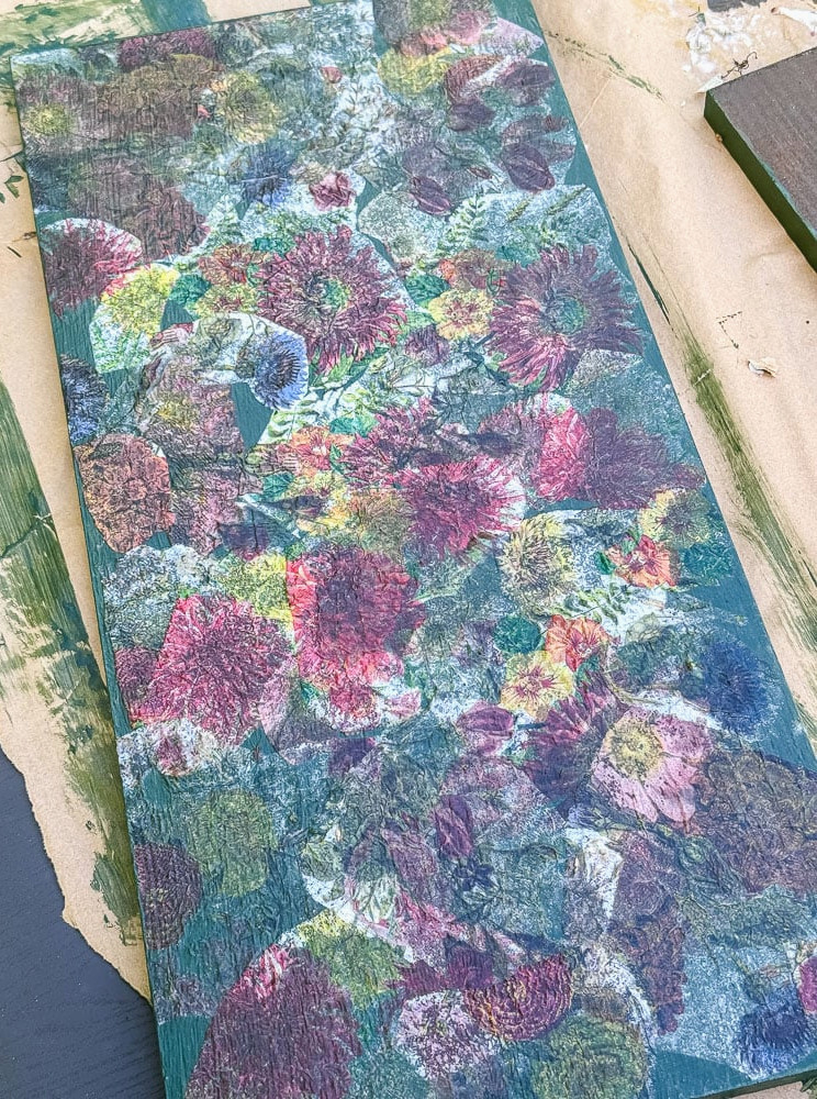 a decoupaged piece of wood that is being used to make a flower press