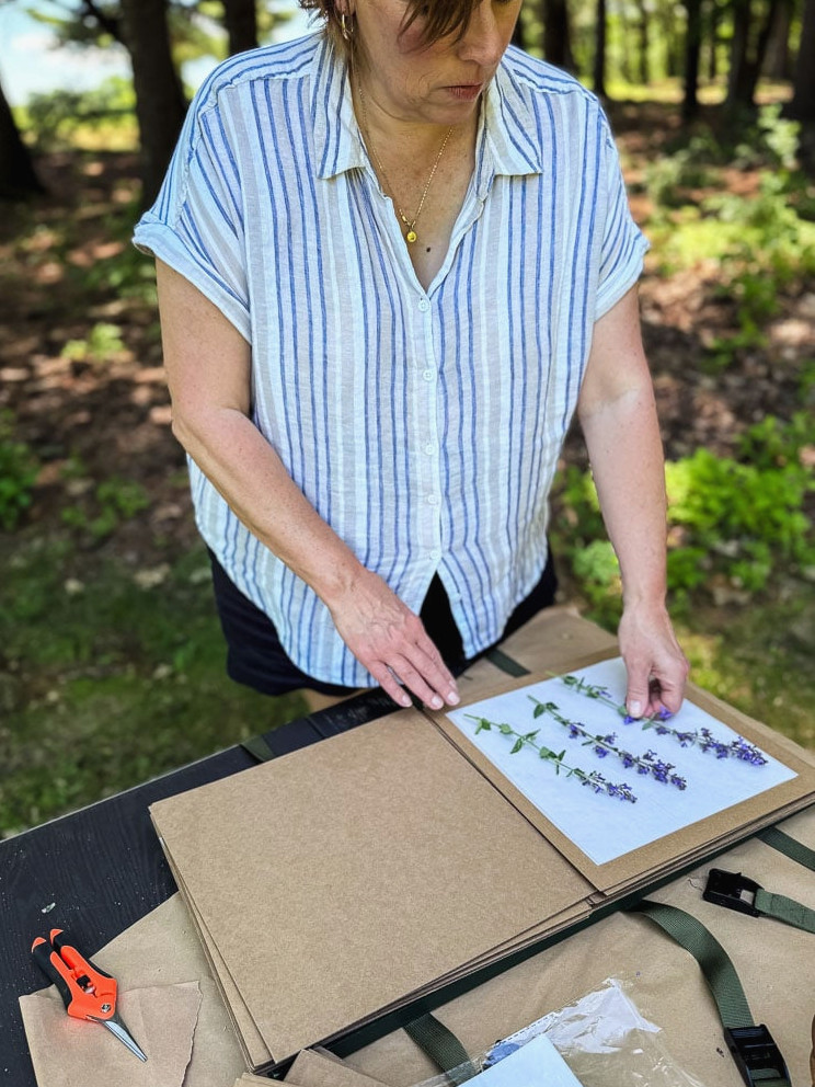 Jennifer Howard filling a flower press outside
