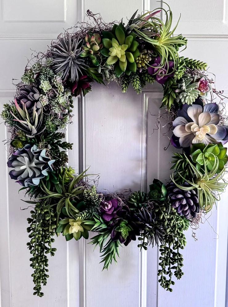 artificial succulent wreath displayed on a door