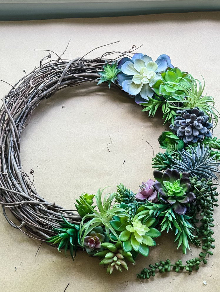an artificial succulent wreath made on grapevine