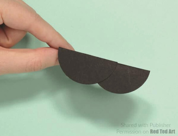 fold the paper circle in half and make a body