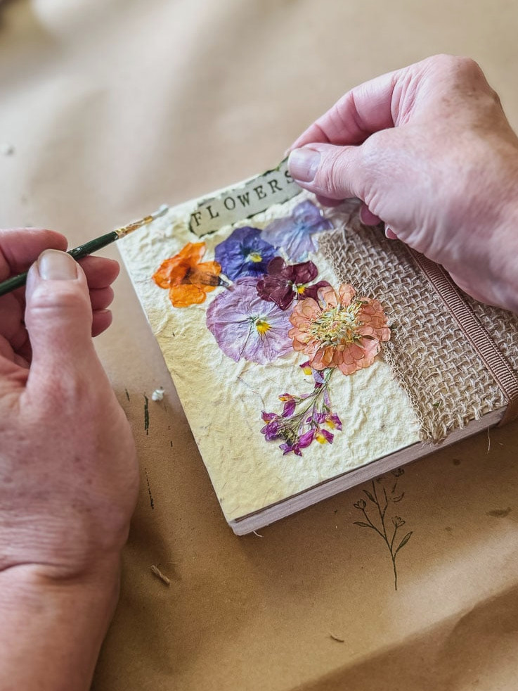 a woman making a flower journal