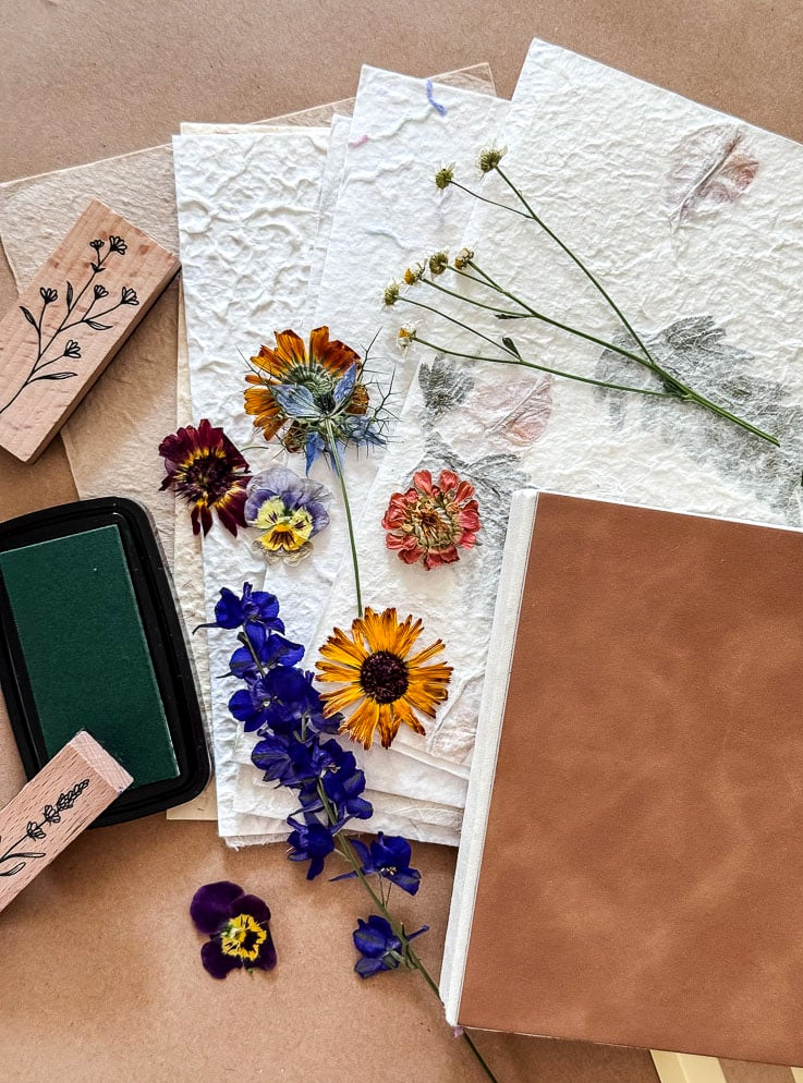 a flatlay of supplies being used to make a handmade flower journal