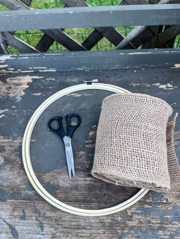 embroidery hoop, roll of burlap ribbon, scissores