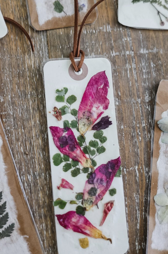 a pressed flower bookmarke with pink petals