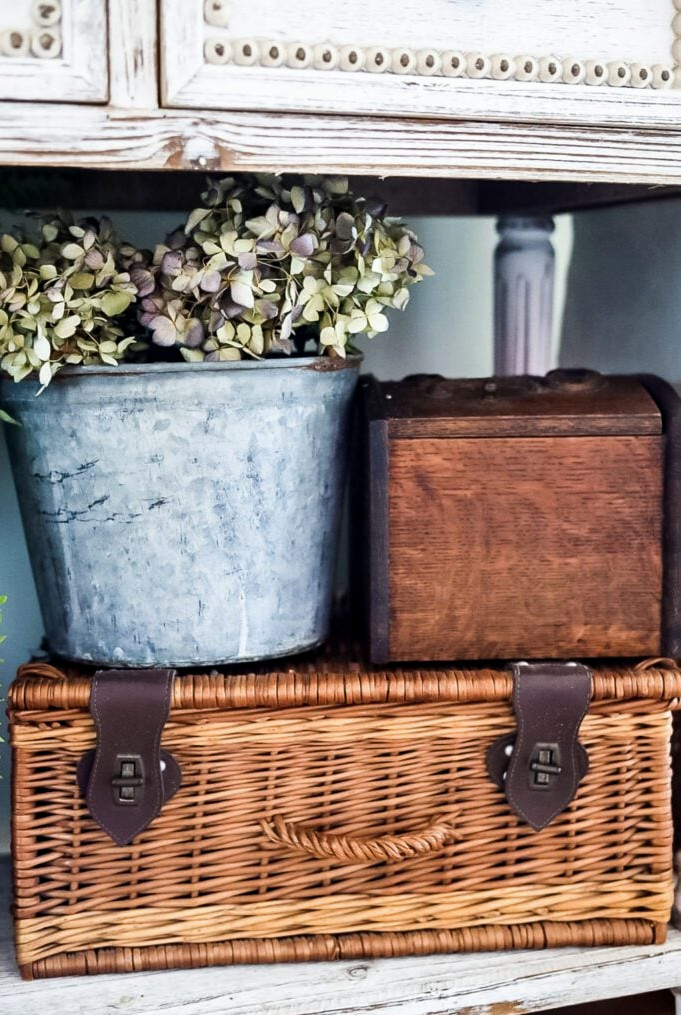 vintage pail with hydrangeas and wicker picnic basket